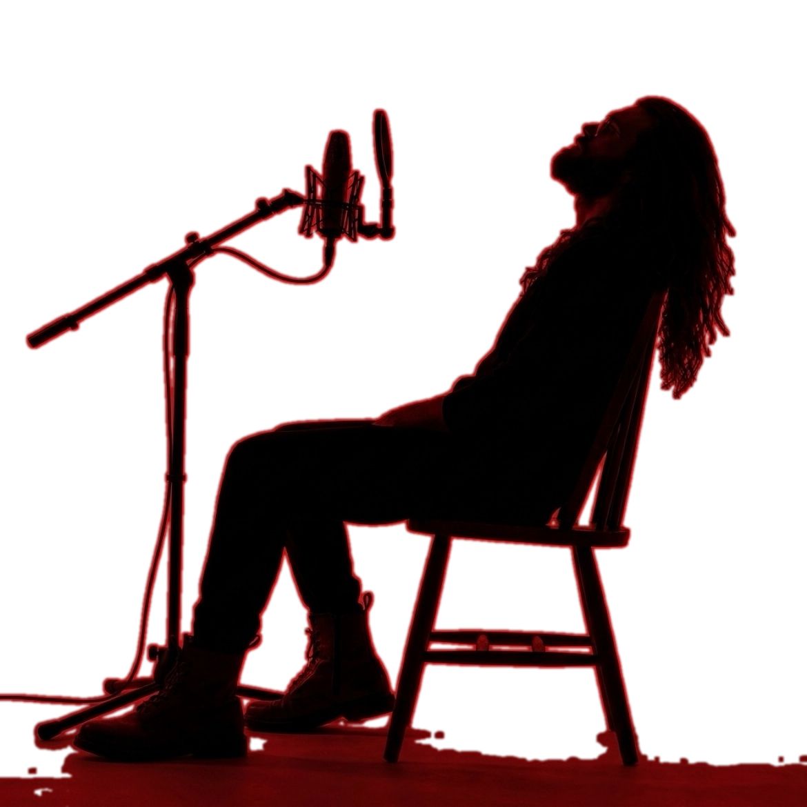 INTITI seated in silhouette beside a studio microphone
